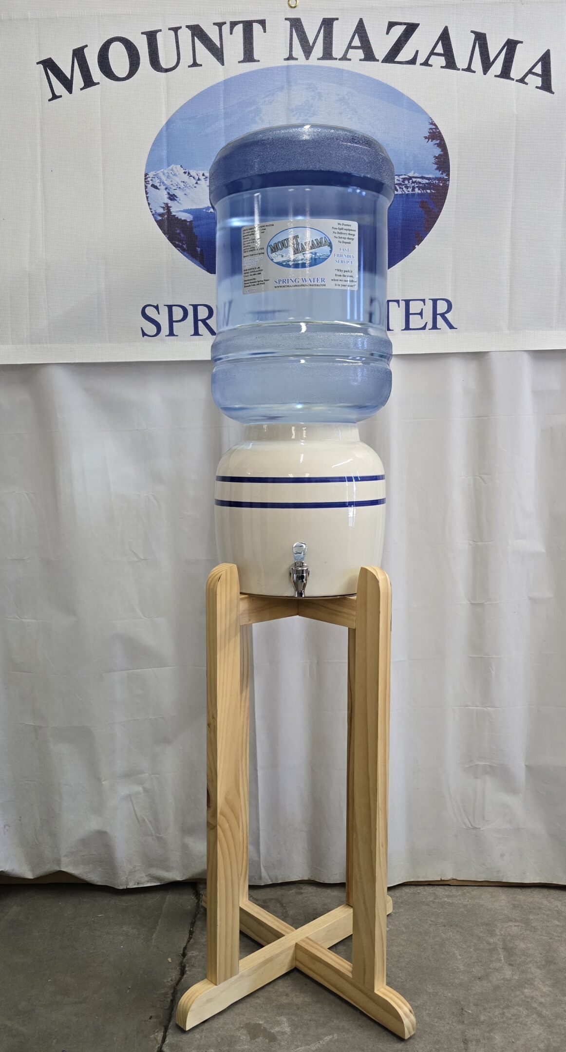 A water dispenser on a wooden stand with a large water bottle.